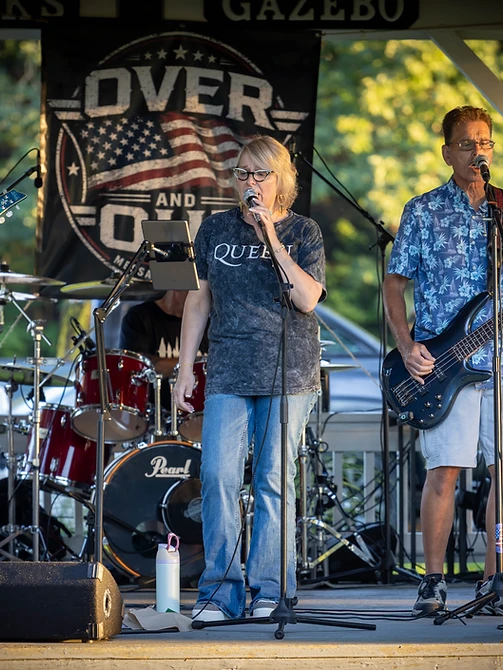 Over and Out on stage at sunset under the gazebo banner