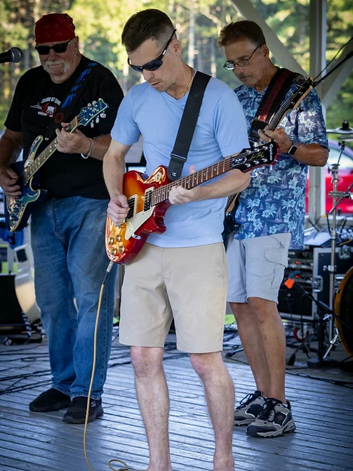 Three guitarists performing together on the gazebo stage