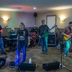 Full band performing together on an indoor stage