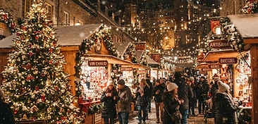 Canadian Christmas market at night with wooden chalets, string lights, and snow-dusted cobblestone streets