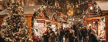 Canadian Christmas market at night with wooden chalets, string lights, and snow-dusted cobblestone streets