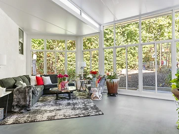 Modern enclosed sunroom with panoramic glass walls