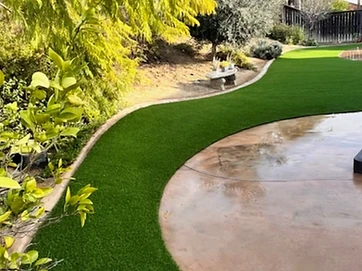 Backyard with artificial grass and custom concrete work