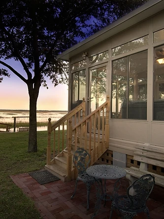Studio-style sunroom glowing at night with glass roof