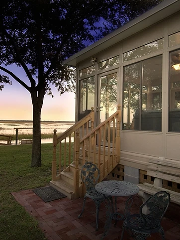 Studio-style sunroom glowing at night with glass roof
