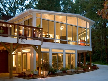Two-story cathedral sunroom glowing at night
