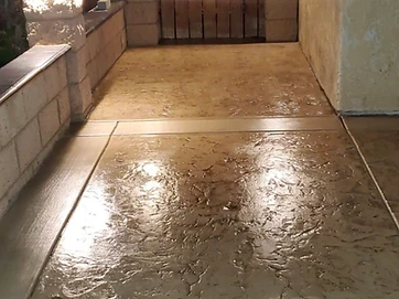 Stamped concrete walkway with retaining walls and integrated lighting at night