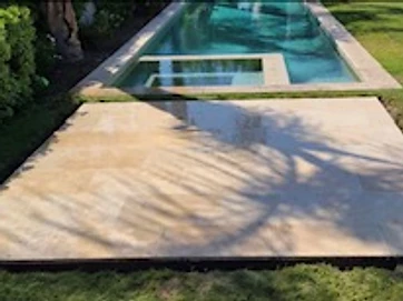 Large-format stone paver patio installed beside a swimming pool