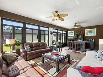 Sunroom interior with ceiling fan and garden views