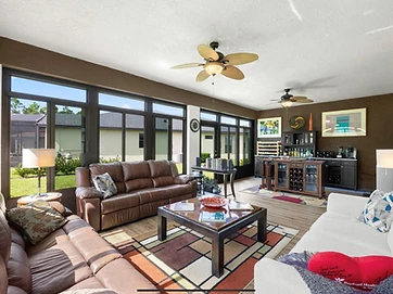 Sunroom interior with ceiling fan and garden views