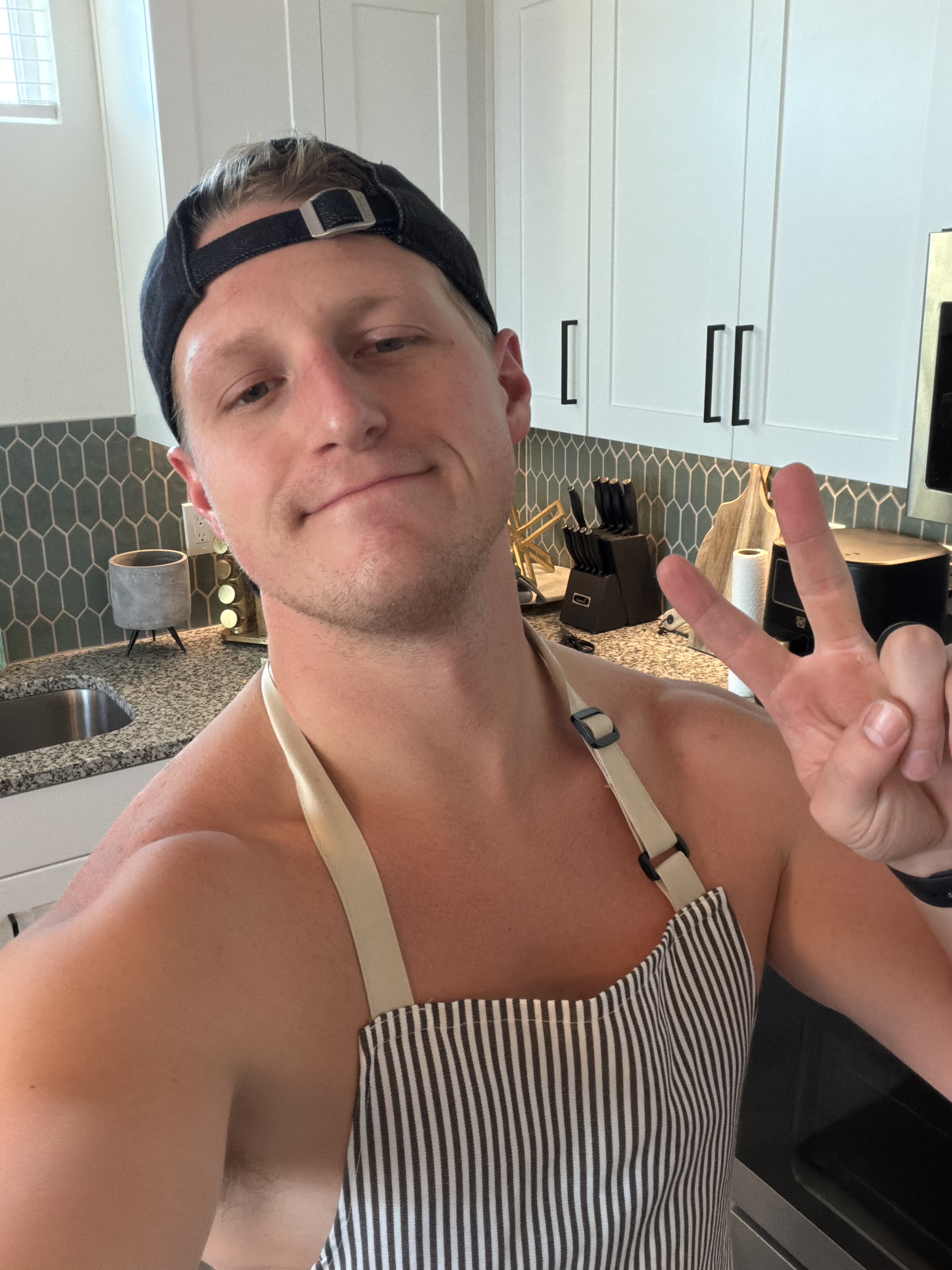 Devin Goff in his kitchen wearing an apron, smiling