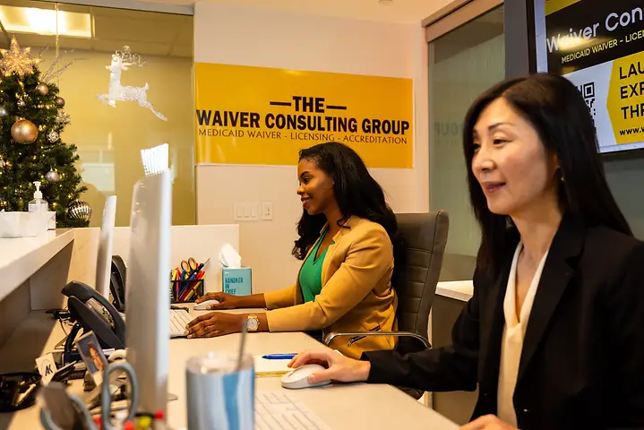 Waiver Consulting Group staff reviewing enrollment portals on dual monitors