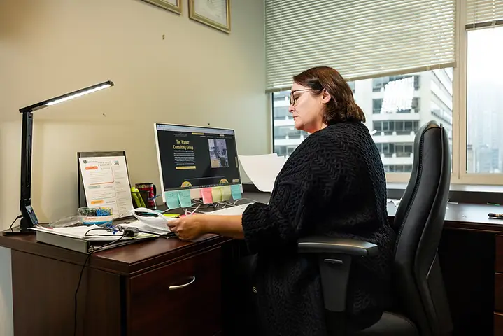 A Waiver Consulting Group specialist reviewing a licensing file at her desk