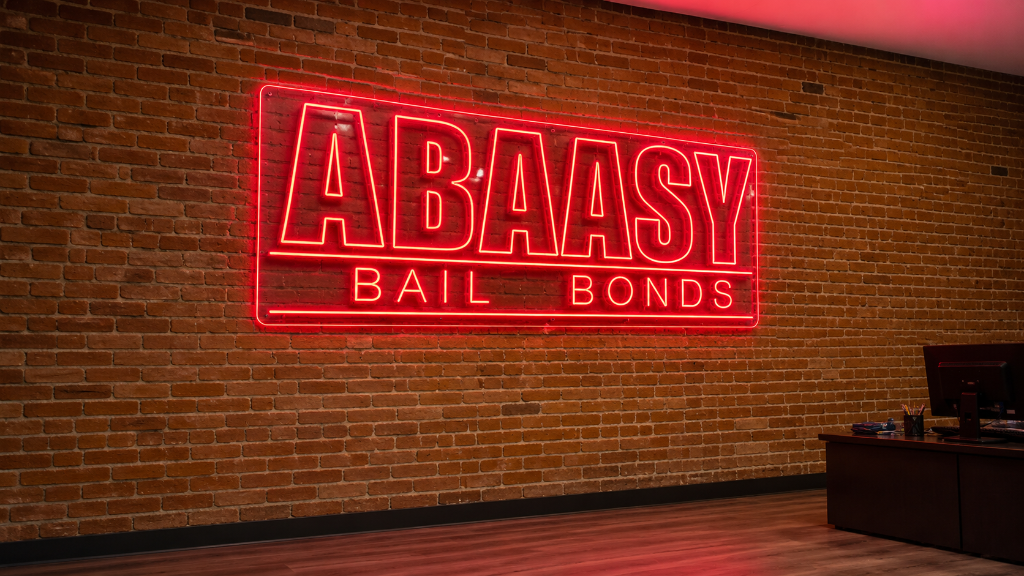 Abaasy Bail Bonds red neon sign on a brick wall