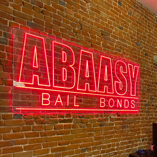 Abaasy Bail Bonds red neon sign on a brick wall