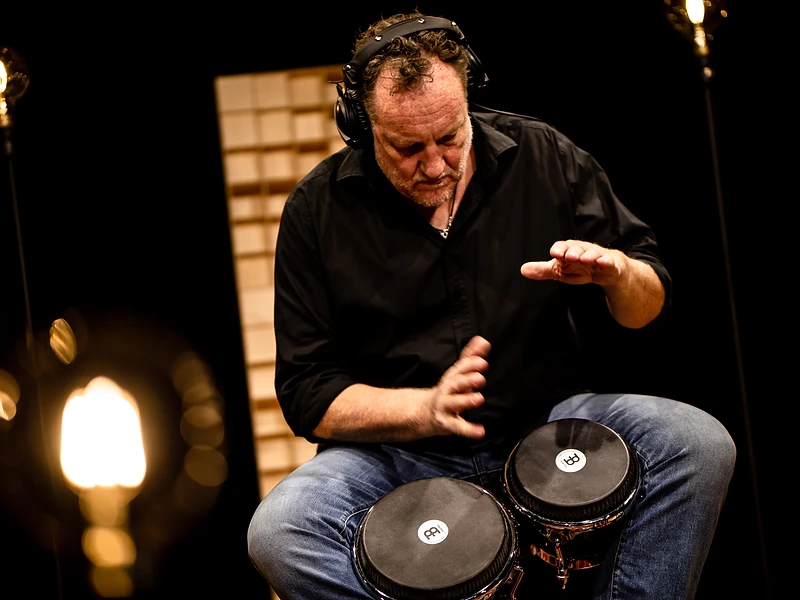 Stephan Maass playing bongos in the studio