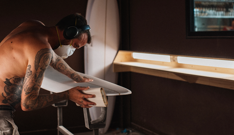 Shaper travaillant une planche de surf dans l’atelier du Shapers Club