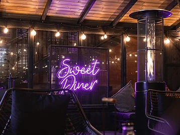 Sweet Diner shisha garden at night with neon sign