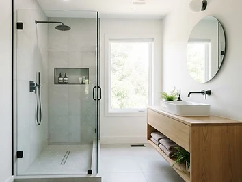 Renovated bathroom with walk-in tile shower and modern vanity