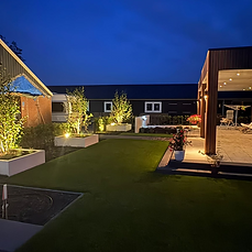 Achtertuin met strakke plantenbakken, verlichting en beplanting