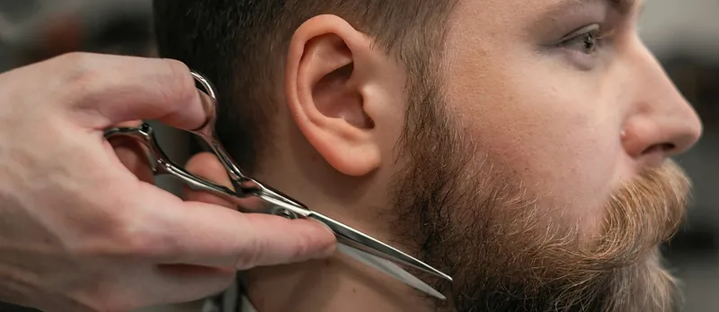 Barber sculpting a beard with shears