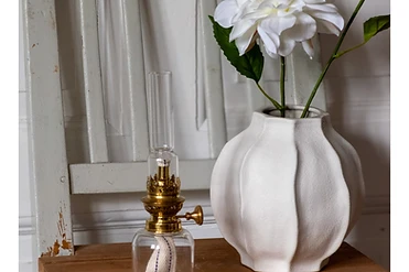 Oljelampa och blomvas på en målad stol — stilleben från butiken