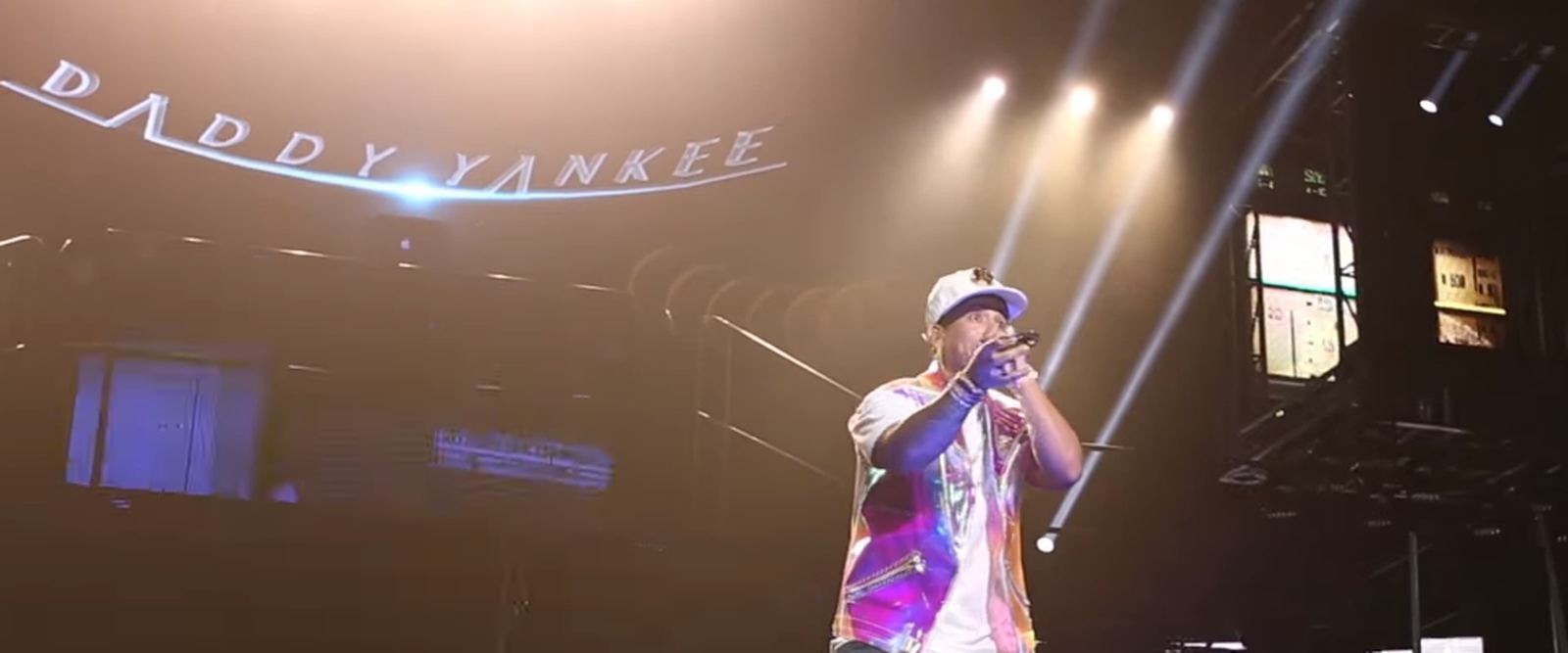 Daddy Yankee performing on stage with his name lit up behind him