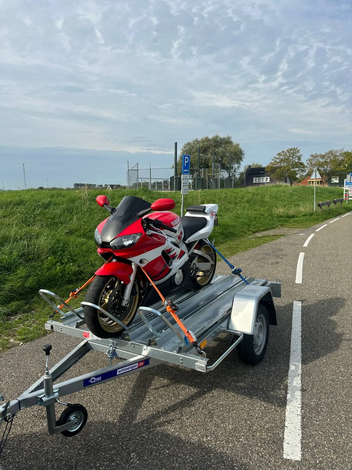 Rood-witte Yamaha R6 vastgezet op een motoraanhanger