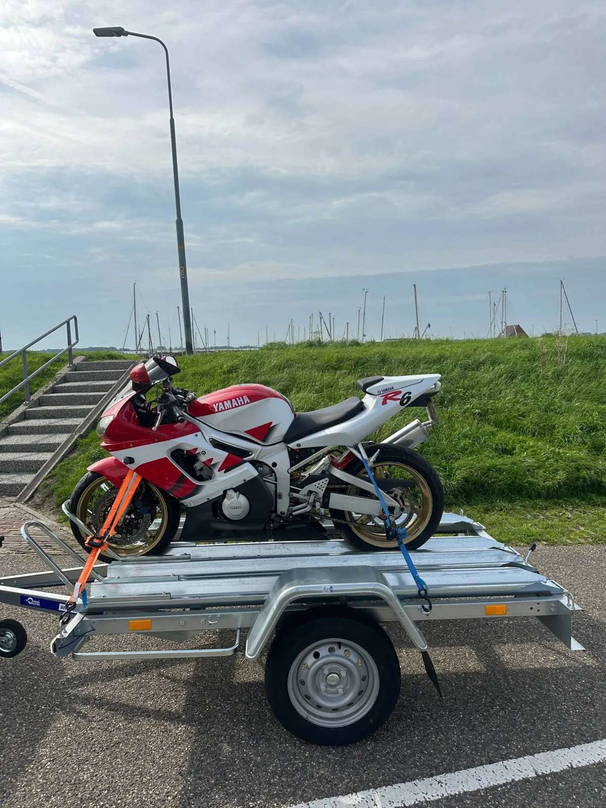 Zijkant van een Yamaha R6 op een motoraanhanger bij de dijk