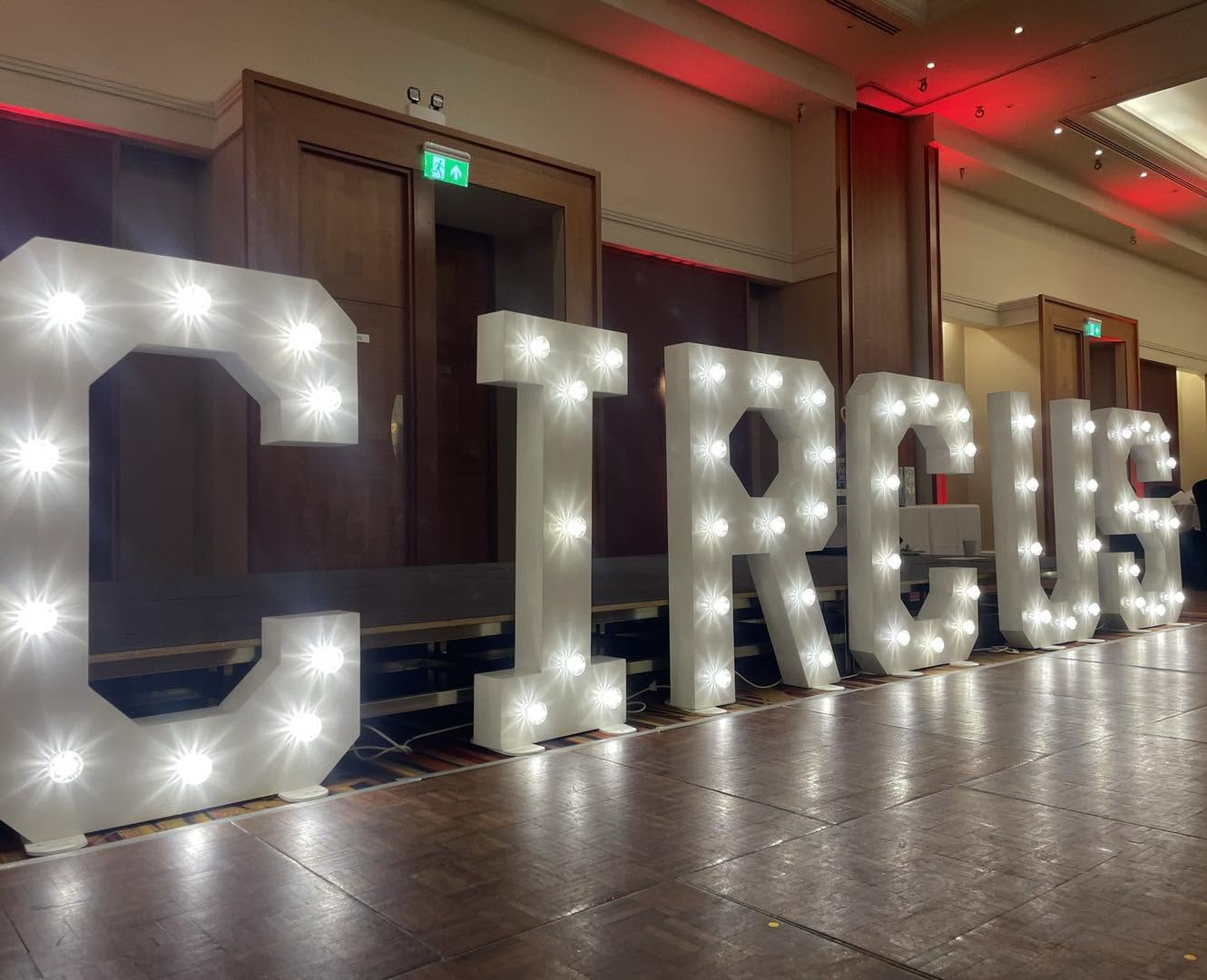 CIRCUS marquee letters on a stage with red accent lighting