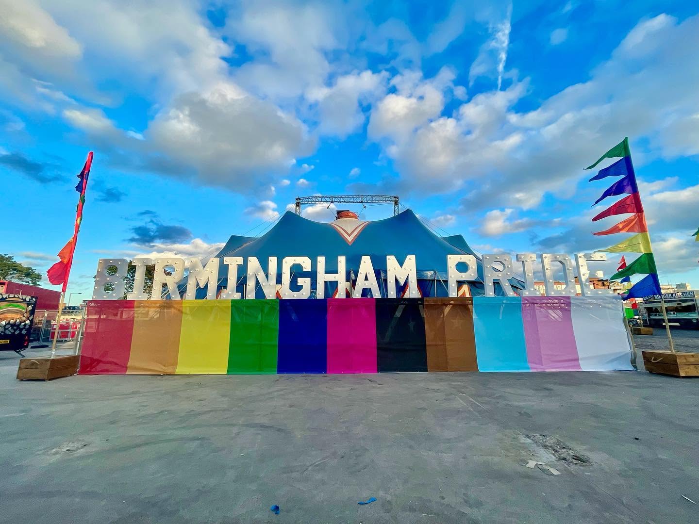 Birmingham Pride marquee sign in the daytime with rainbow backdrop