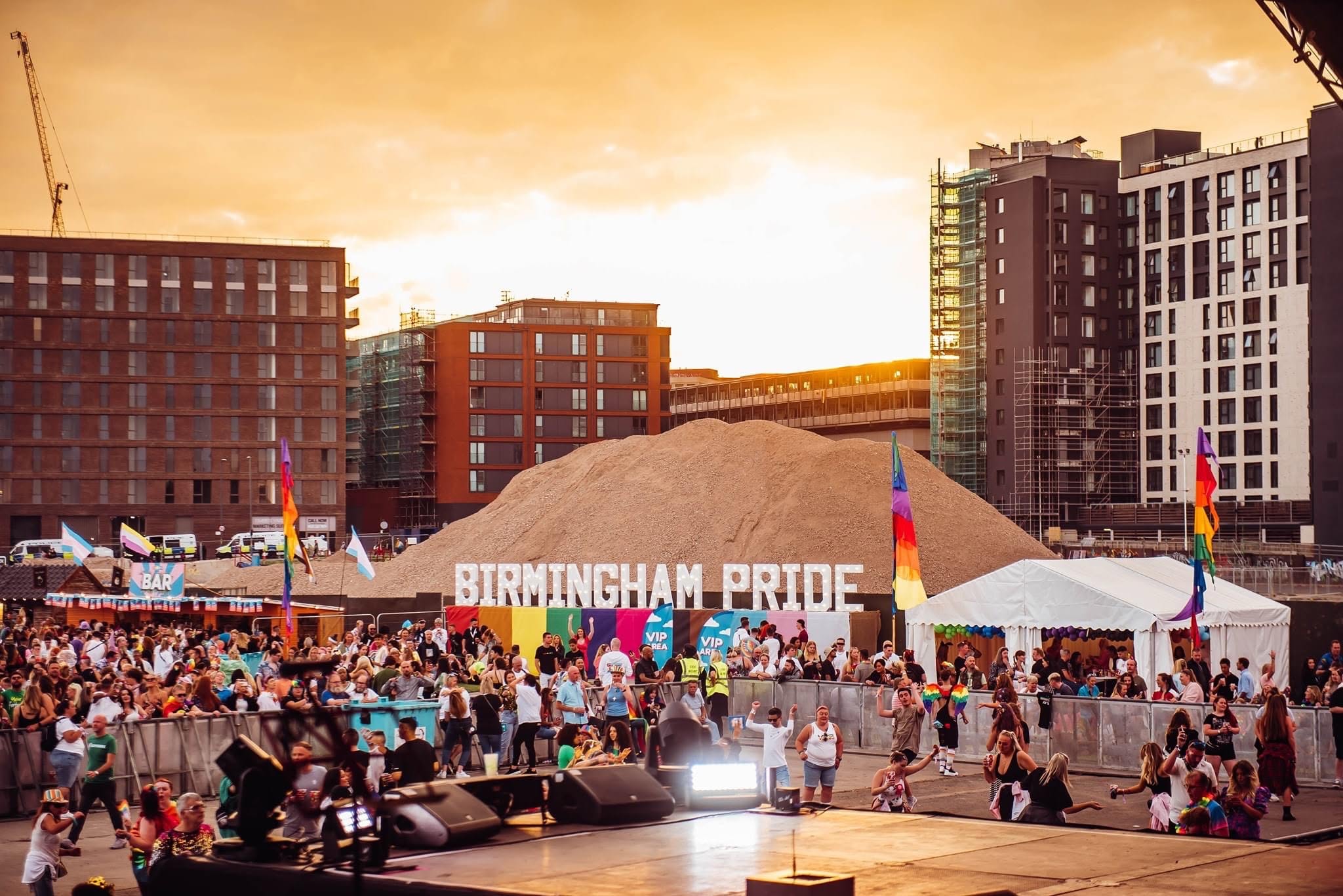 Birmingham Pride light-up letters at sunset with crowd and flags