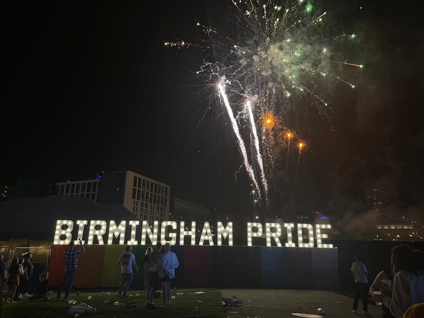 Birmingham Pride light-up letters with fireworks overhead at night