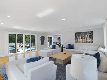 Living room angle showing sliding doors to the deck and the full seating arrangement