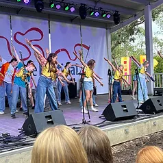 Students performing on stage in gold sequined vests