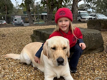A student smiling while hugging Winston the wellbeing dog