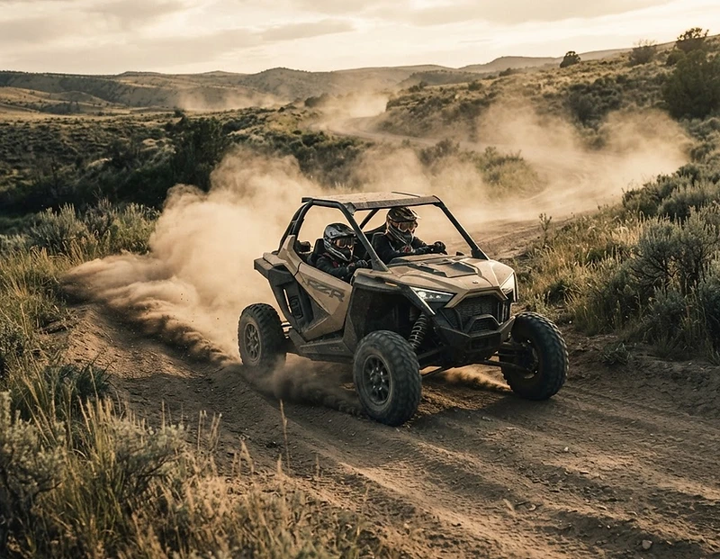 Side-by-side on a dirt trail kicking up dust