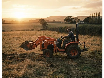 Compact tractor with front loader in a field