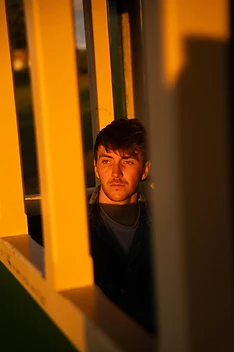Max White framed by a sunlit yellow window
