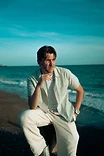 Max White seated overlooking the sea