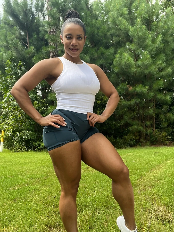 Woman performing a heavy hack squat, supported deep range work for glute and quad growth