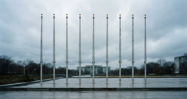 Row of ceremonial flagpoles under an overcast sky
