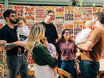 Família reunida para foto em frente ao painel da Casa do Tatu