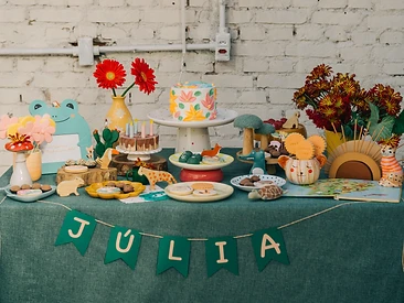 Mesa de festa artesanal com bolo decorado e peças de cerâmica