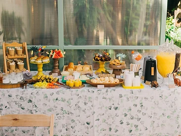 Mesa de festa com comida de verdade: frutas, pão de queijo e suco natural