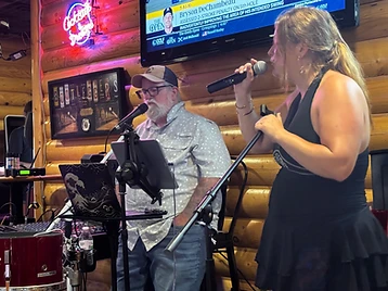 Faye singing while Corey plays guitar at a live show