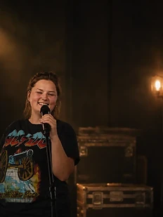 Faye singing under warm stage light
