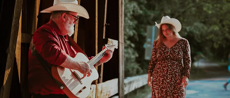 Faye and Corey together on a covered bridge at golden hour