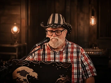 Corey singing at the microphone in a stars-and-stripes hat