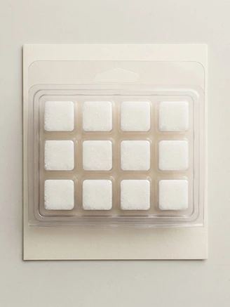 Individual sugar cube body exfoliators in a clear clamshell package